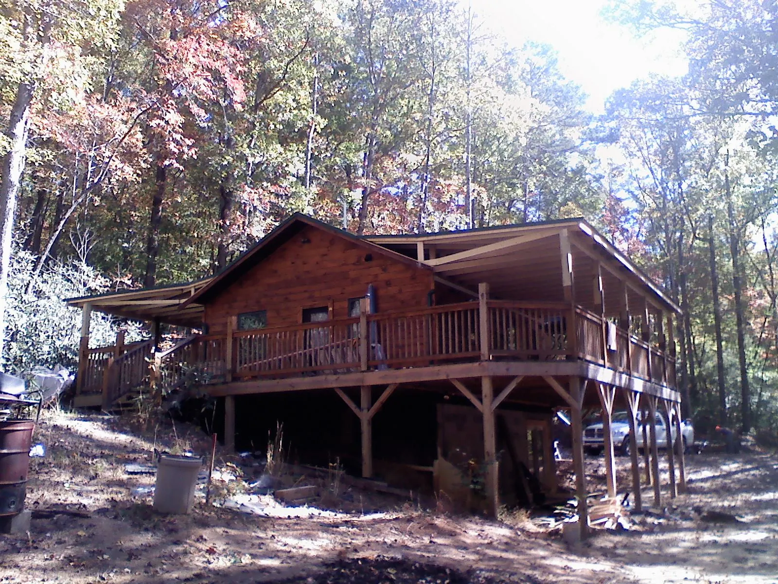 Log cabin with a wraparound porch and metal roof in the fall in Mount Vernon